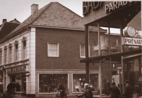 Babyparadijs op de hoek van de Heuvelstraat in Tilburg, met de winkelpui en voorbijgangers op straat.