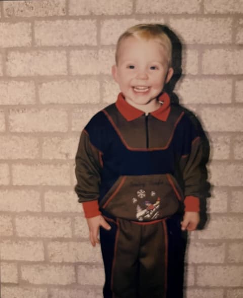 Rutger van Happen als kindmodel in een bruin-blauw trainingspak uit de eigen collectie.