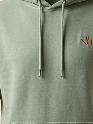 Detail van het geborduurde Villa Happ embleem op de hoodie.