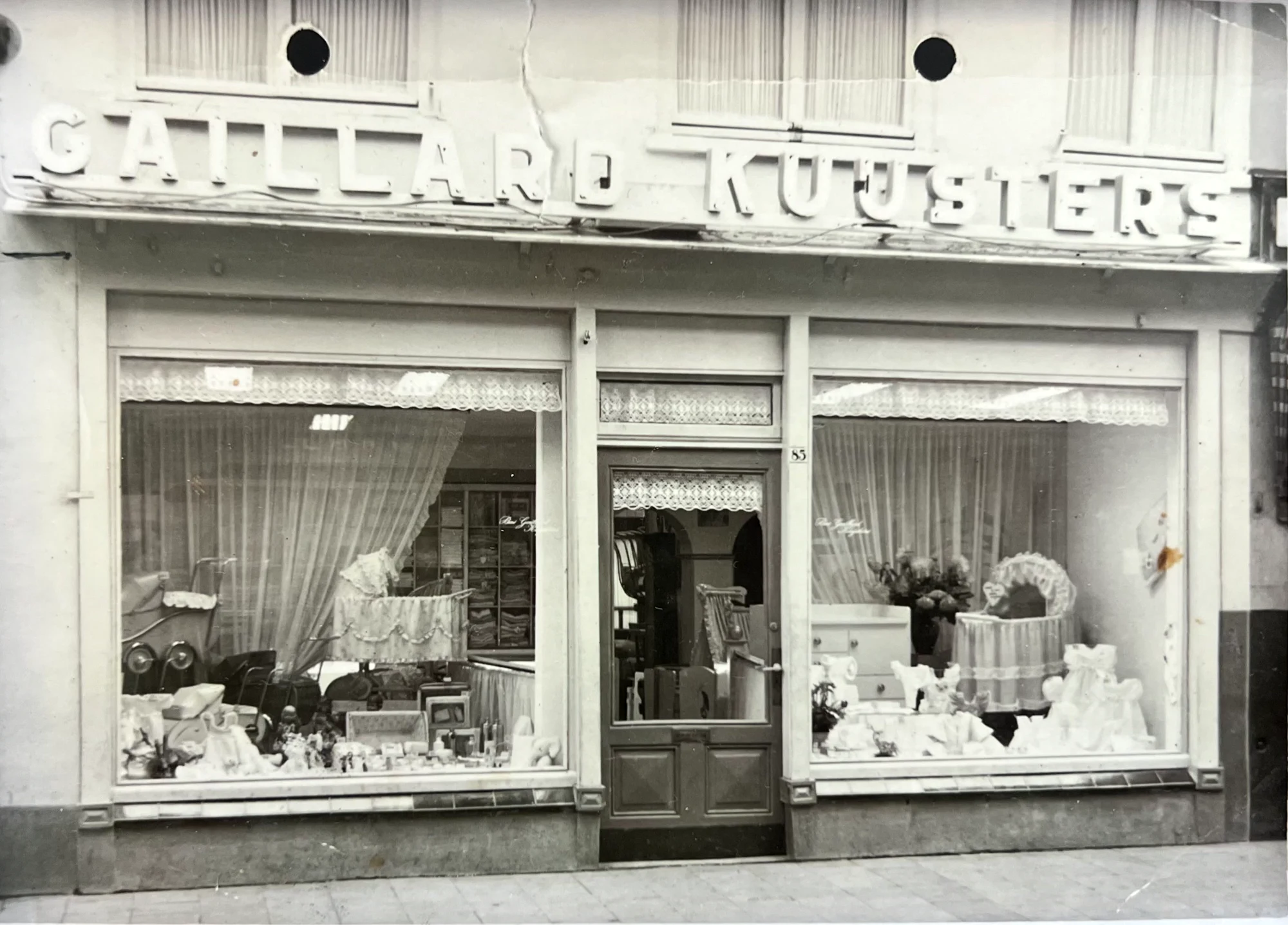 De winkel Gaillard Kuijsters aan de Heuvelstraat 85 in Tilburg, met twee etalages vol kinderwagens, wiegjes en babygoed.